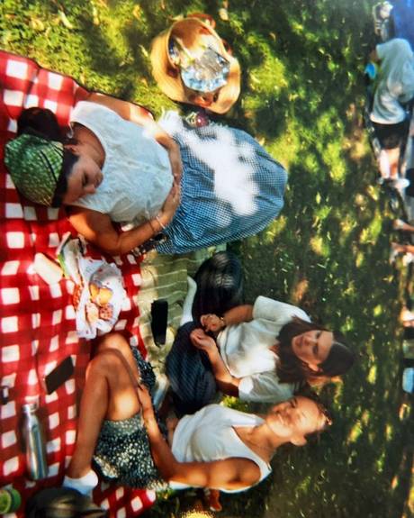 Friends lying in the grass with drinks